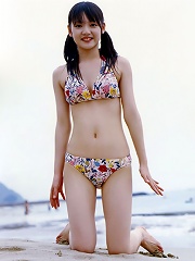 Two beautiful asian babes showing off their bodies in bikinis