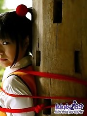 Asian slut in pigtails and uniform shows her hairy pussy and her favorite toys